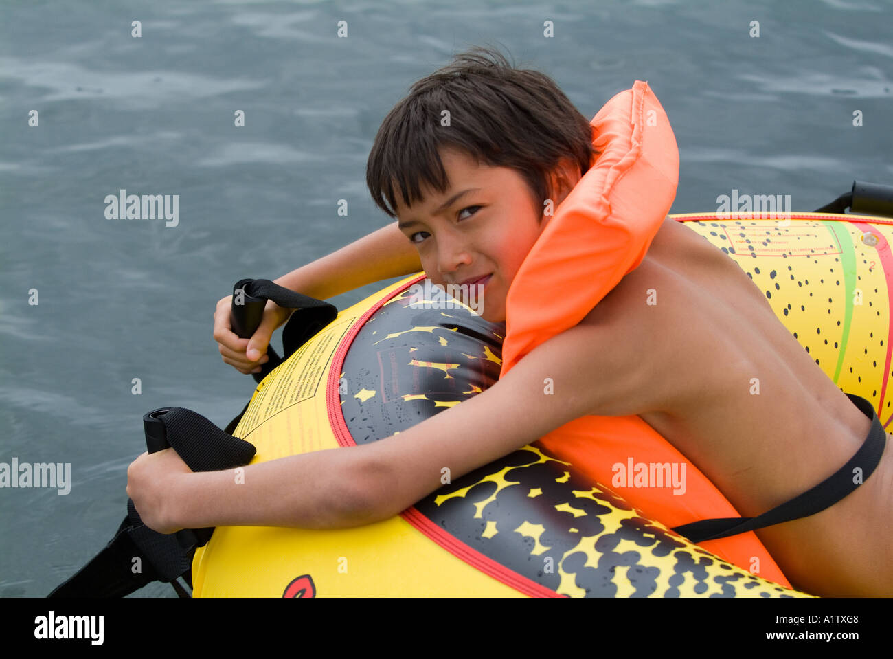 Boy wearing a life jacket lying on an inflatable raft Biscarrosse lake