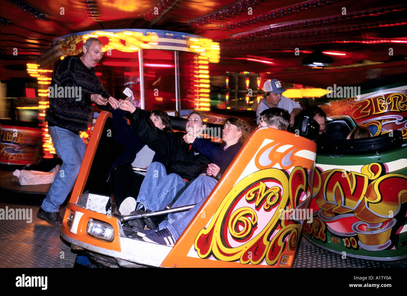 FAIRGROUNDS.A worker spins a car with girls in it on the  BANBURY FAIR WALTZER 1996 Stock Photo