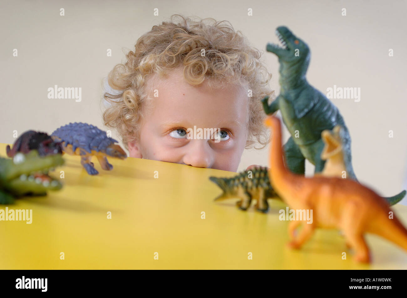 A young boy playing with dinosaurs at a nursery school Stock Photo