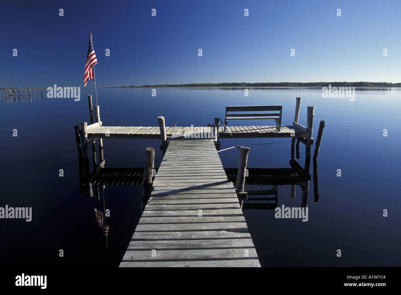 Early morning boat dock and star spangled banner flag over calm