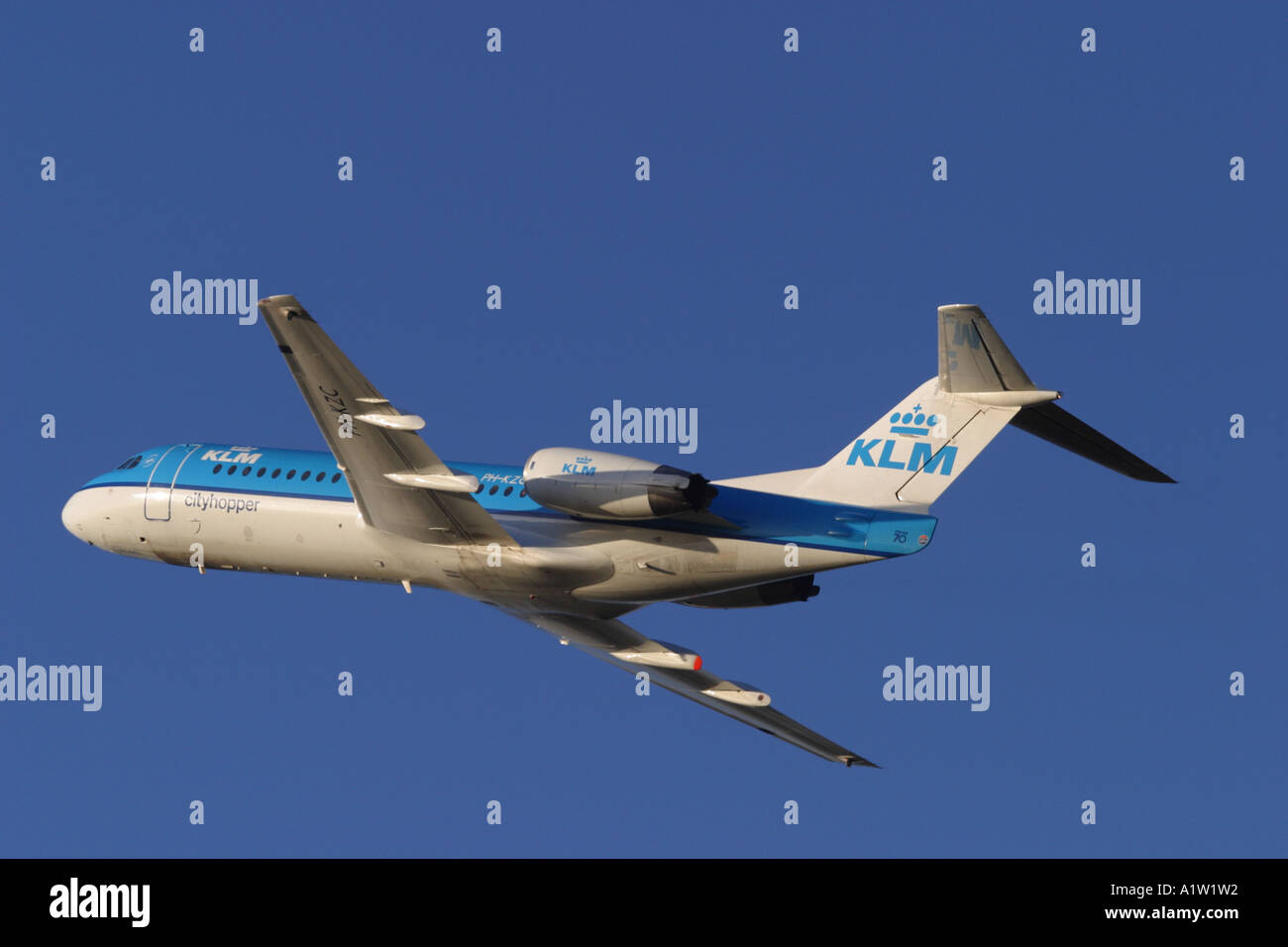 KLM Fokker 70 jet airliner taking off into a blue sky Stock Photo