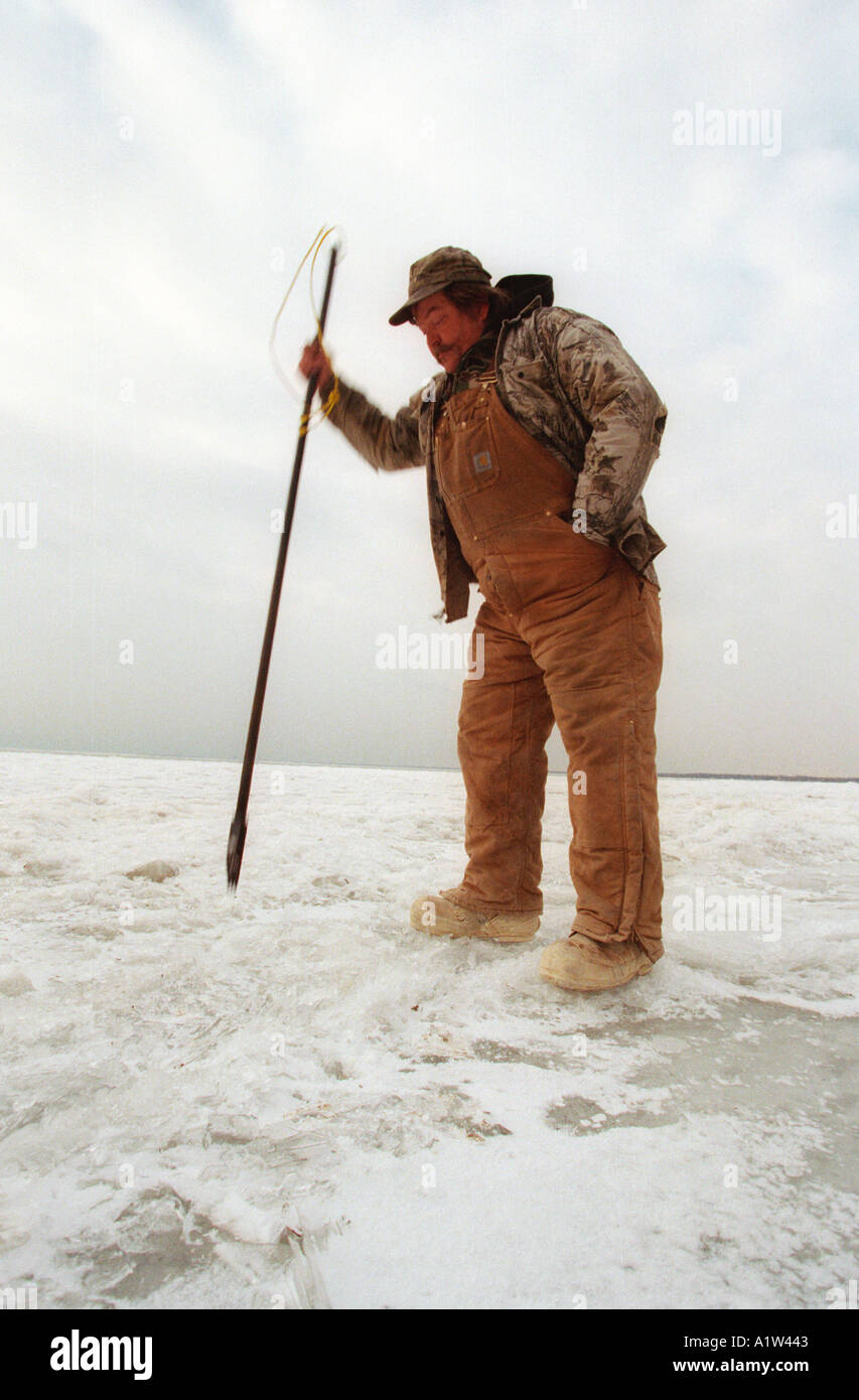 Ice fisherman checks thickness of ice on Lake St Clair Stock Photo