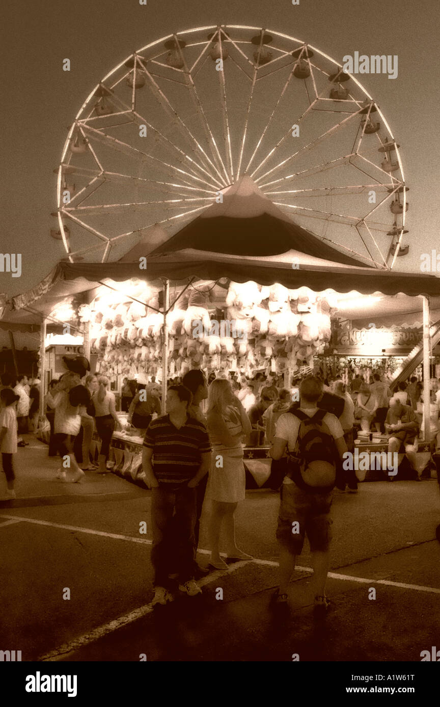 Moody sepia toned view of teenagers on carnival midway near Ferris