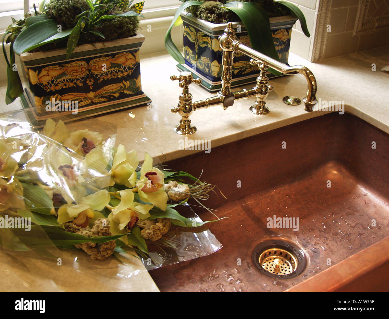 vintage style copper sink with cut orchids Stock Photo