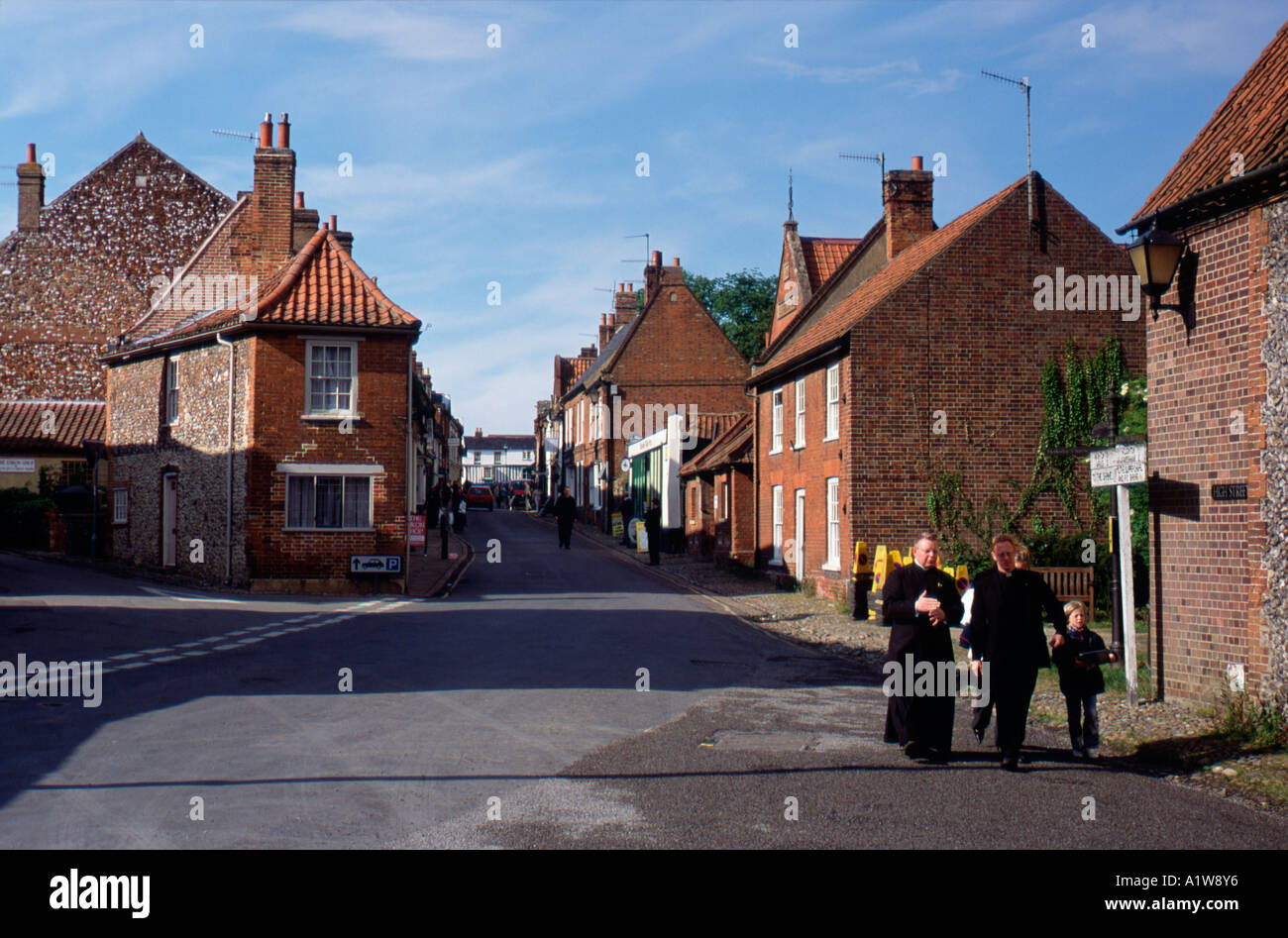 Priests walking down street Walsingham Norfolk england english britain