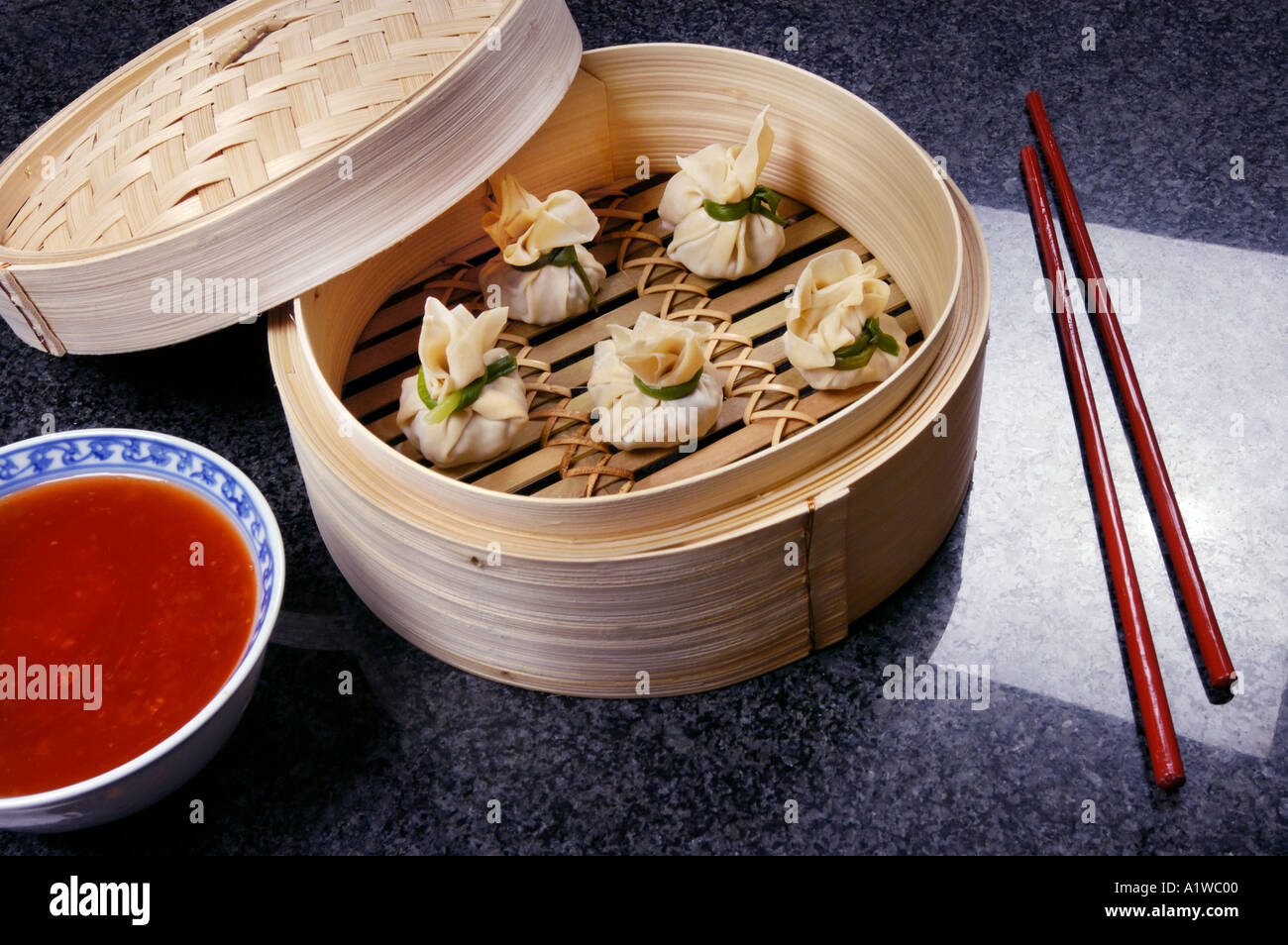 DIM SUM prepared in bamboo steamer with red hot sauce steam eat food