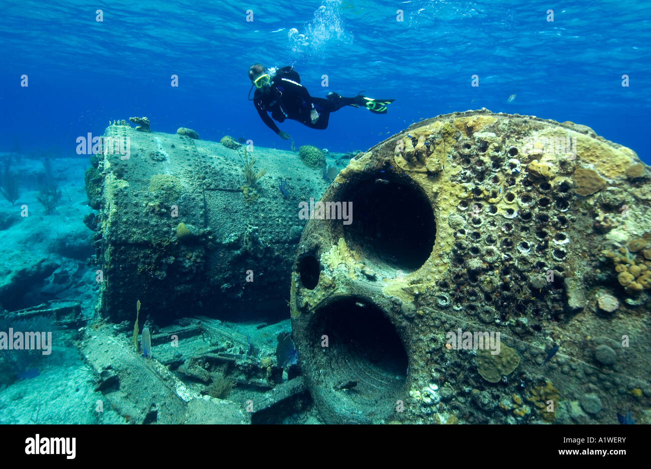 DIVER SWIMS ABOVE BOILERS AND OTHER PIECES OF DEBRIS FROM THE FRASCATE SHIPWRECK NEAR SAN SAN SALVADOR BAHAMAS Stock Photo