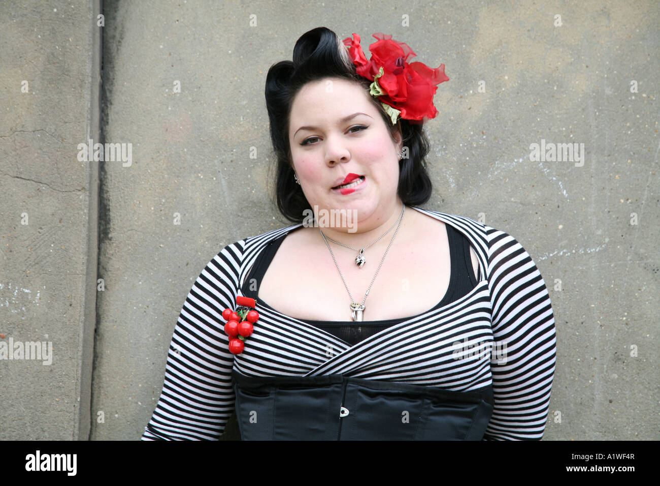 Portrait of a punk girl wearing tight clothes and red flowers, UK 2006 Stock Photo