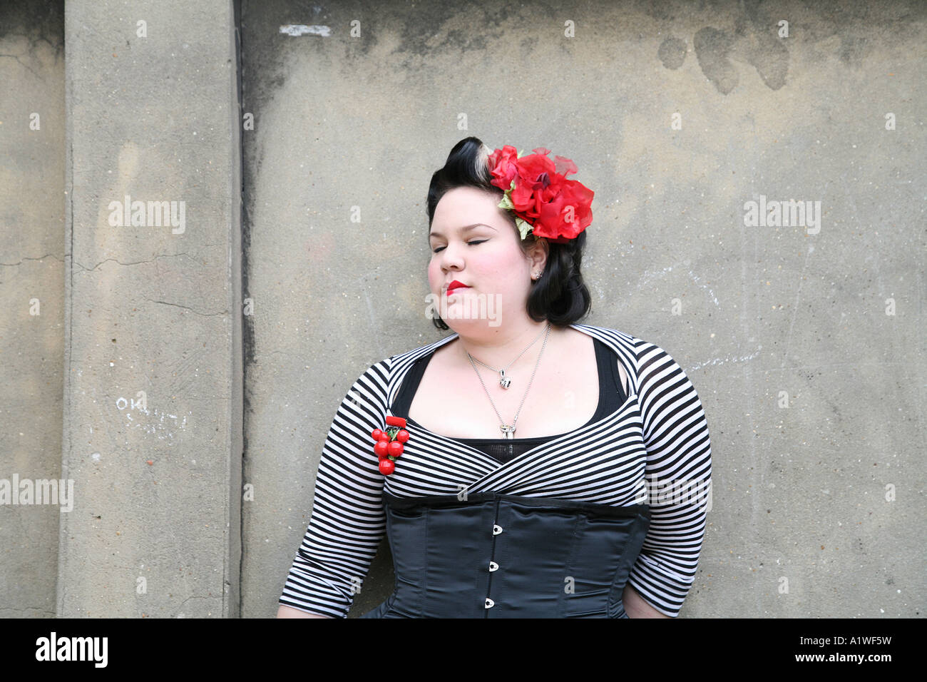 Portrait of a punk girl wearing tight clothes and red flowers, UK 2006 Stock Photo