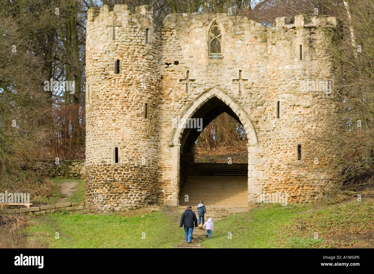 Family walking towards Sham Castle Folly built by George Nettleton the entrance to Roundhay Park Leeds West Yorkshire England Stock Photo