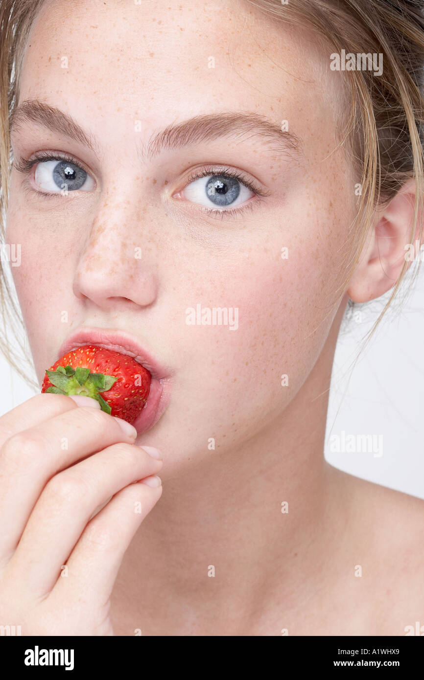 Portrait of a young woman eating strawberry Stock Photo