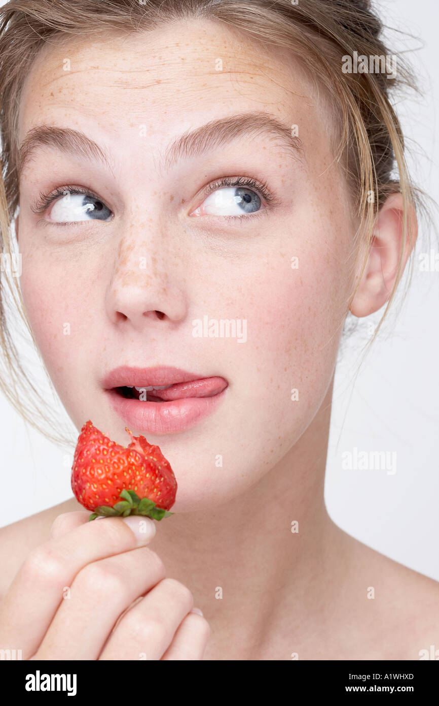 Portrait of a young woman eating a strawberry Stock Photo