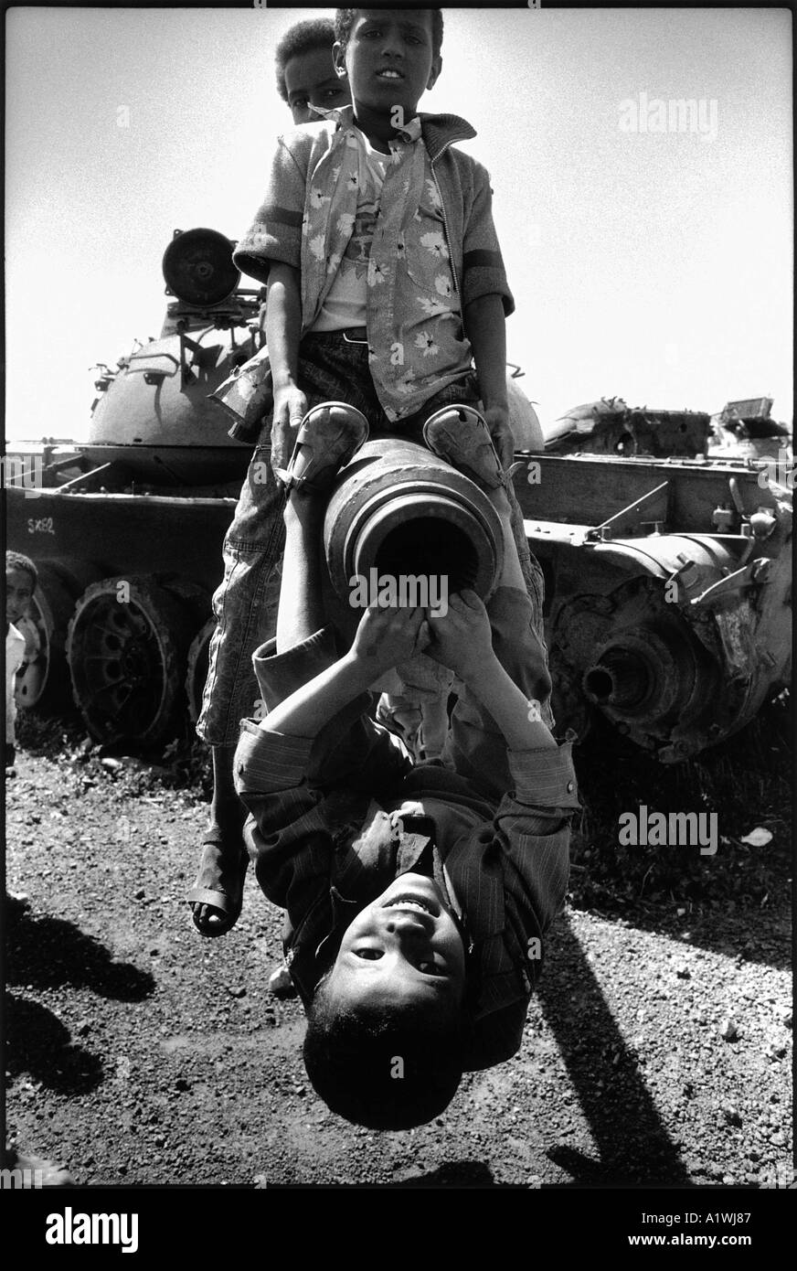 Children play on an old abandoned tank in a scrapyard for tanks from the ERITREAN WAR FOR INDEPENDENCE FROM ETHIOPIA Stock Photo