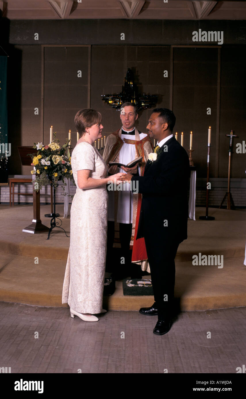 CHRISTIAN MARRIAGE. Bride and groom in front of vicar who is blessing their  wedding Stock Photo - Alamy, image size:856x1390