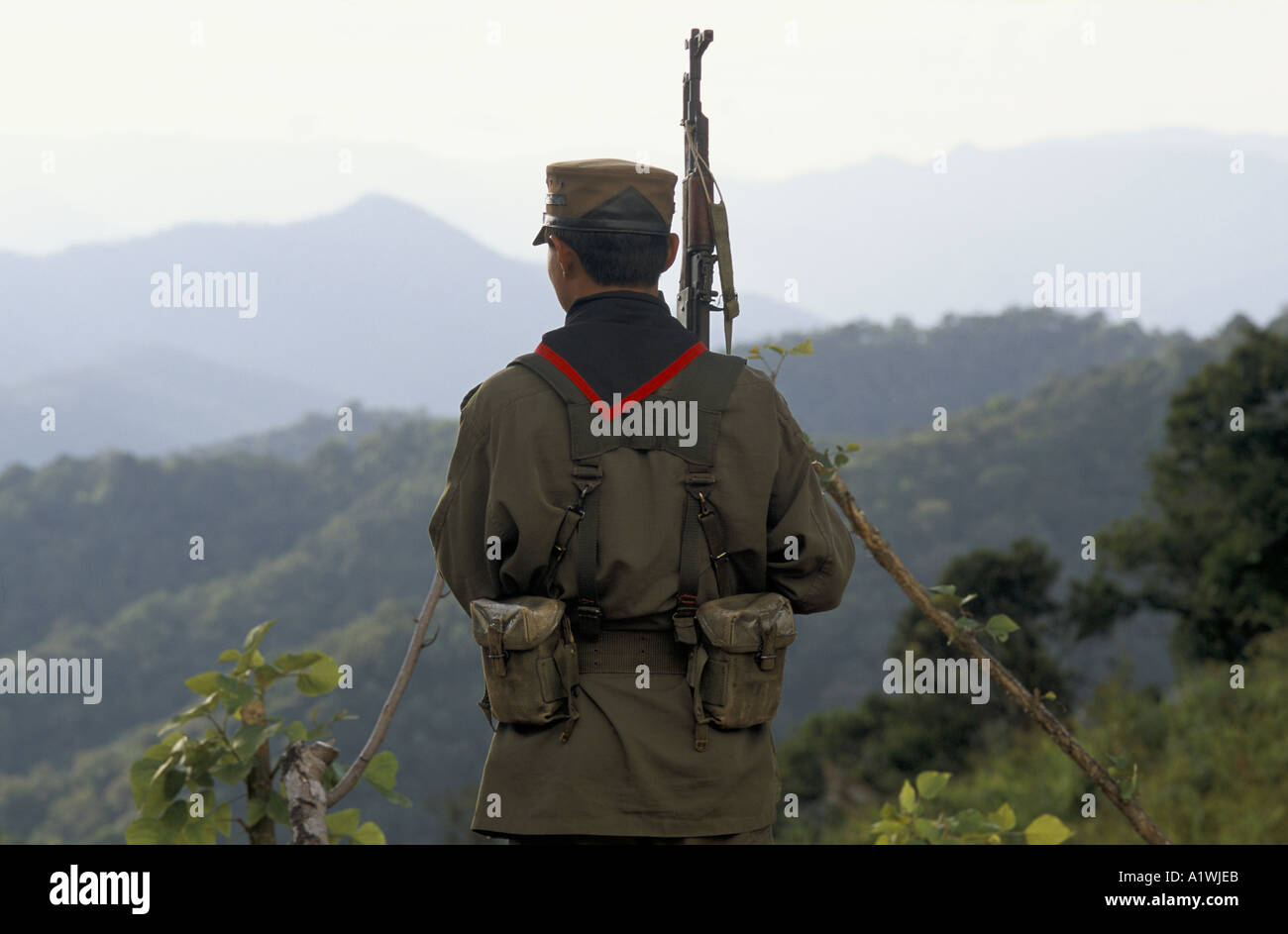 BURMA. A SHAN STATE ARMY GUERILLA LOOKS OUT OVER A HILL TRIBE VILLAGE THAT IS SUSPECTED OF GROWING OPIUM 2001 Stock Photo