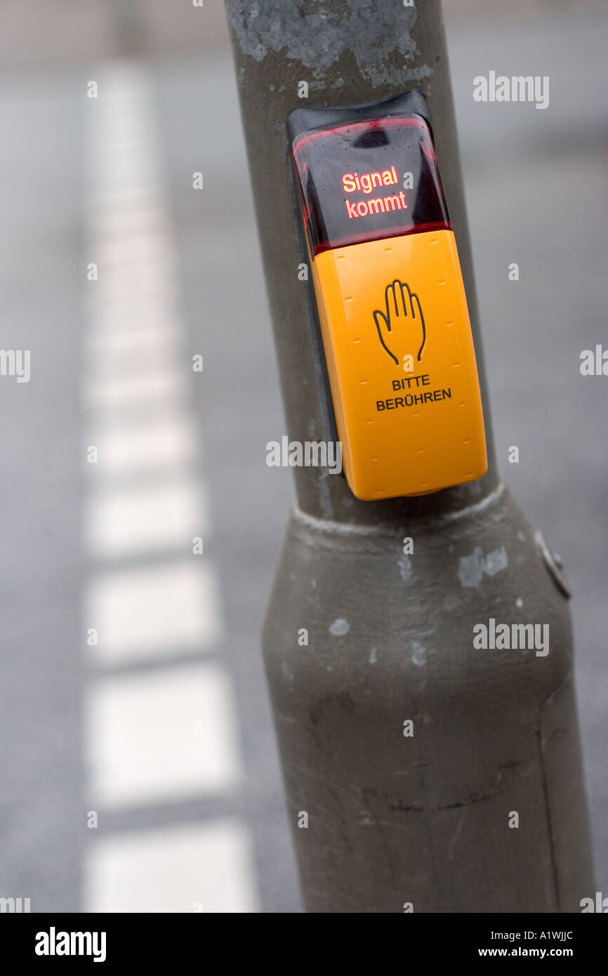 Yellow push button at a pedestrian crossing with writing in german Stock Photo