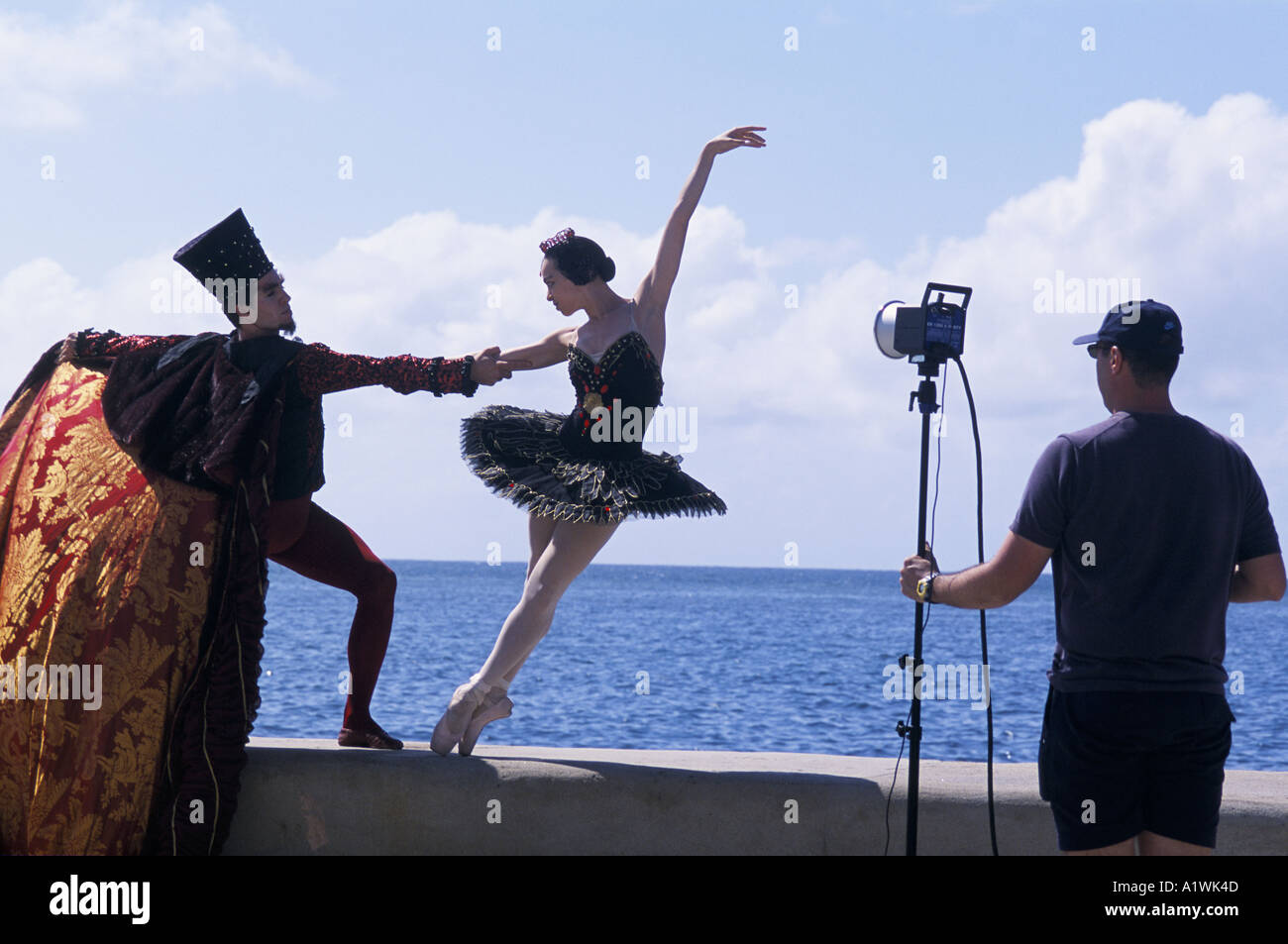 Malecon.BALLET DANCER S WEARING THEATRICAL  COSTUMES POSE HOLDING ONTO EACH OTHERS ARMS FOR A PHOTO SHOOT IN FRONT OF THE SEA Stock Photo