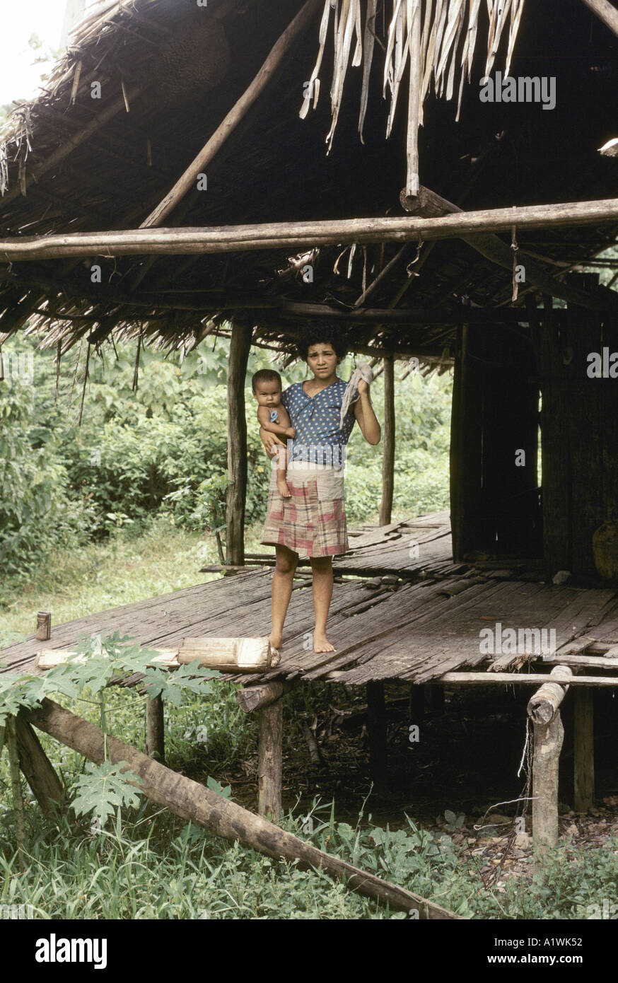 MOTHER AND CHILD , STANDING ON PORCH OF WOODEN THATCHED HOME AMAZONIA Stock Photo