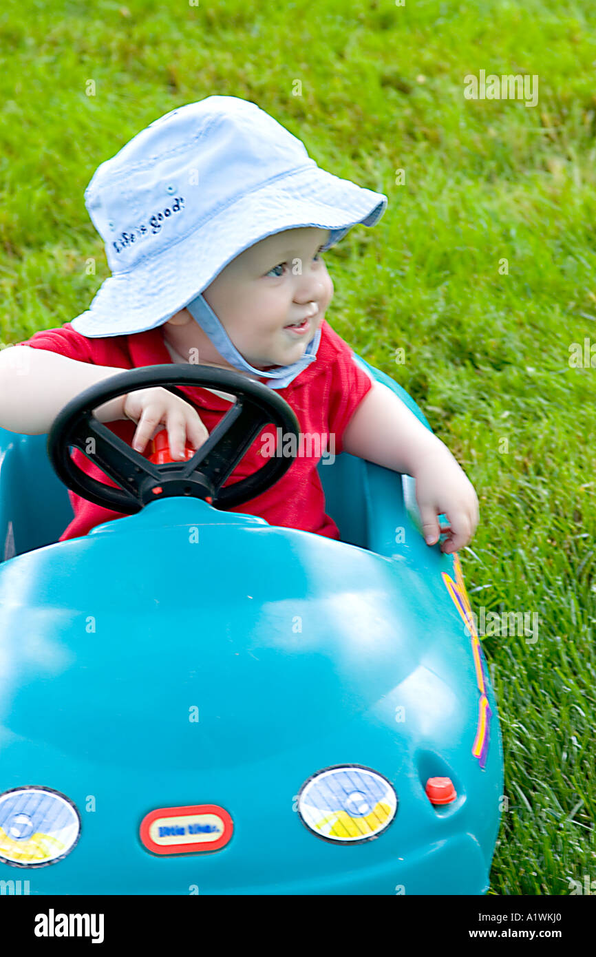 One year old boy with a hat. Life is good riding in a toy car Stock