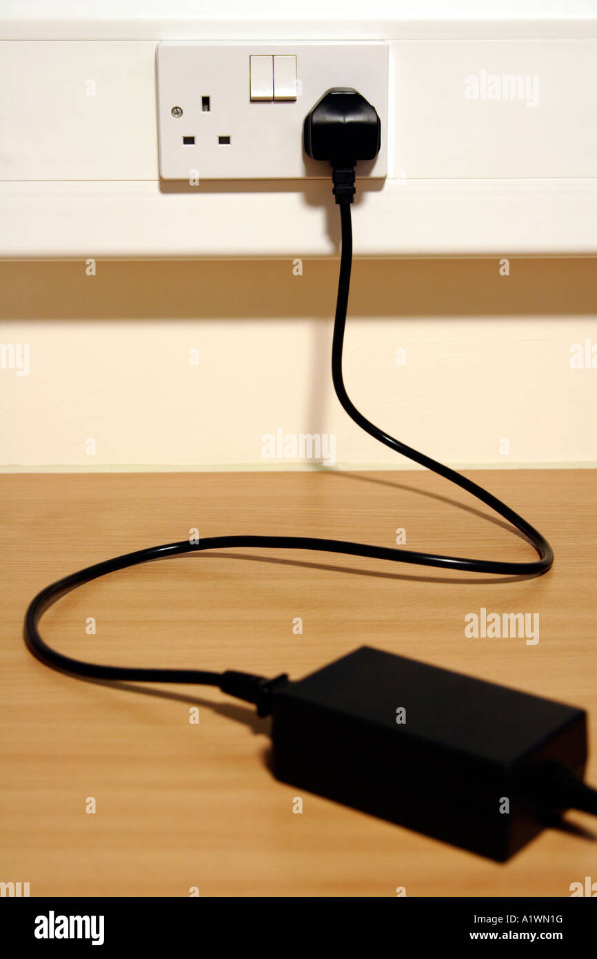Power cord plugged into mains socket Stock Photo