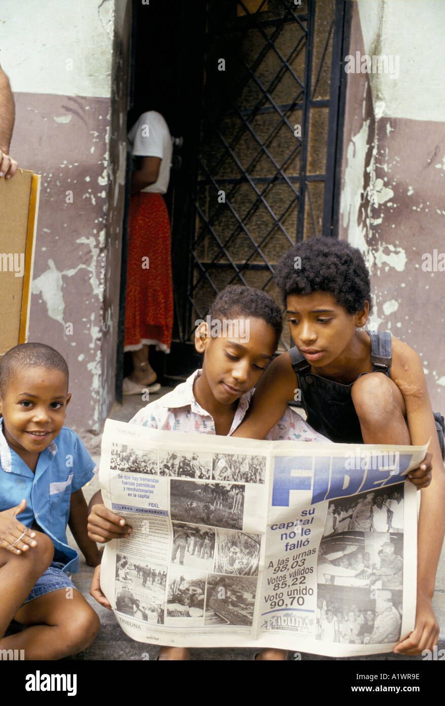 CUBA . CHILDREN READING NEWSPAPER SHOWING ELECTION RESULTS FOR FIDEL CASTRO 1993 Stock Photo