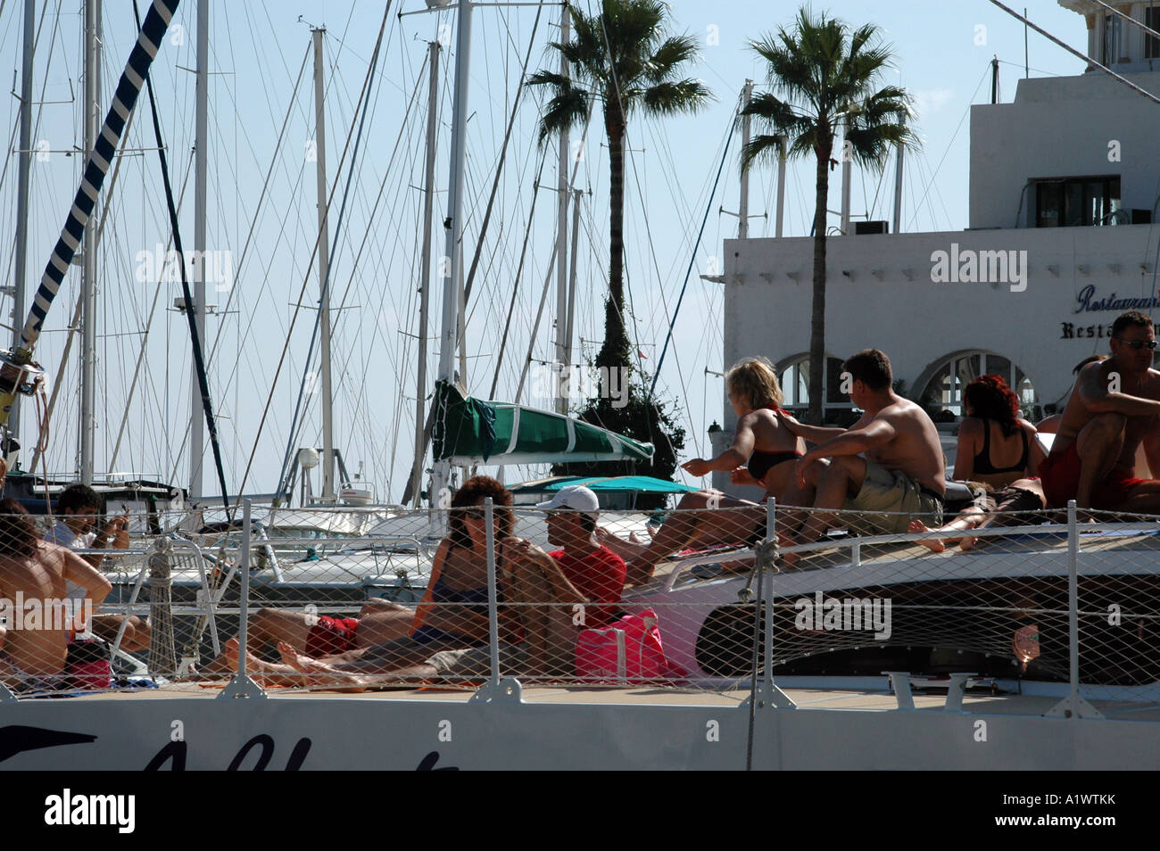 Tourists sunbathing on catamaran pleasure boat in Port El Kantaoui marina in Tunisia Stock Photo