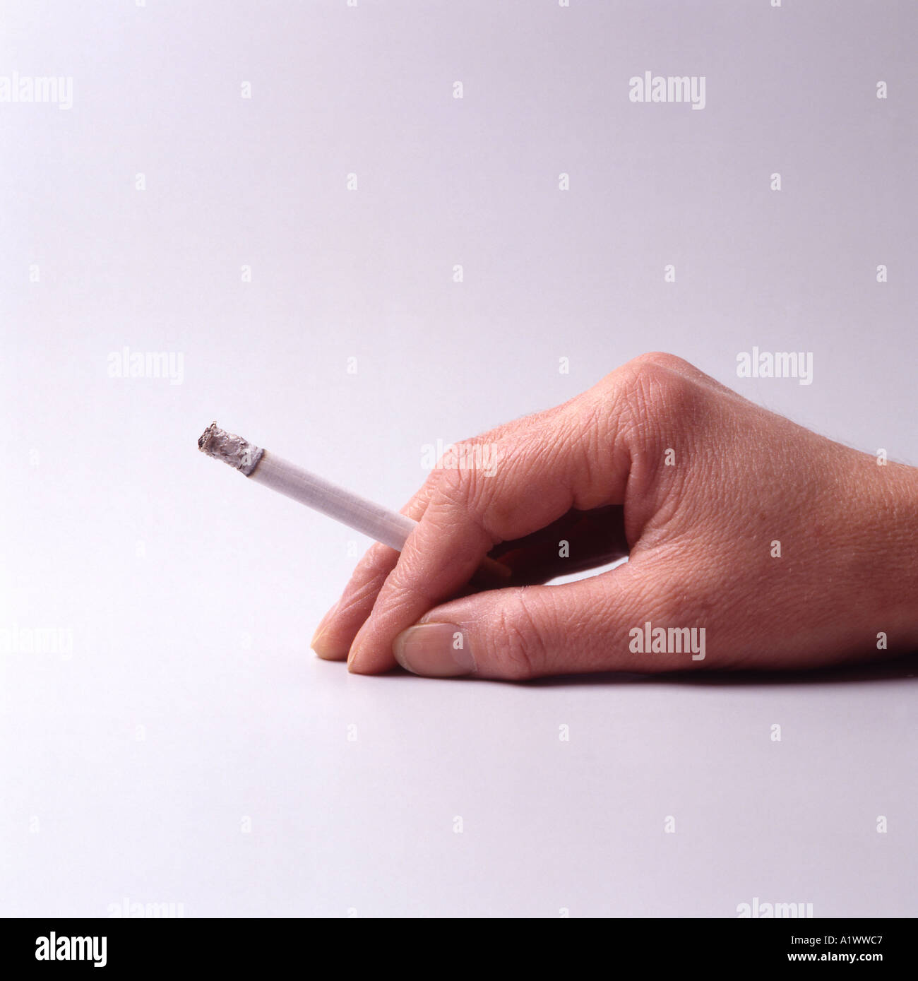 Cigarette between fingers Stock Photo