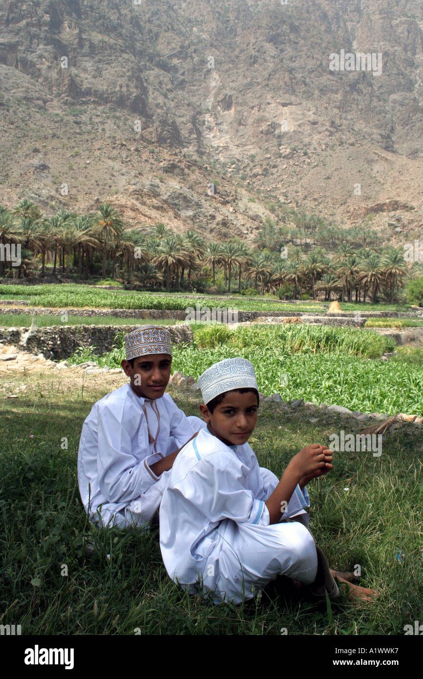 Boys resting in the shade, Bilad Sayt village Wadi Bani Hajar Mountains Oman Stock Photo