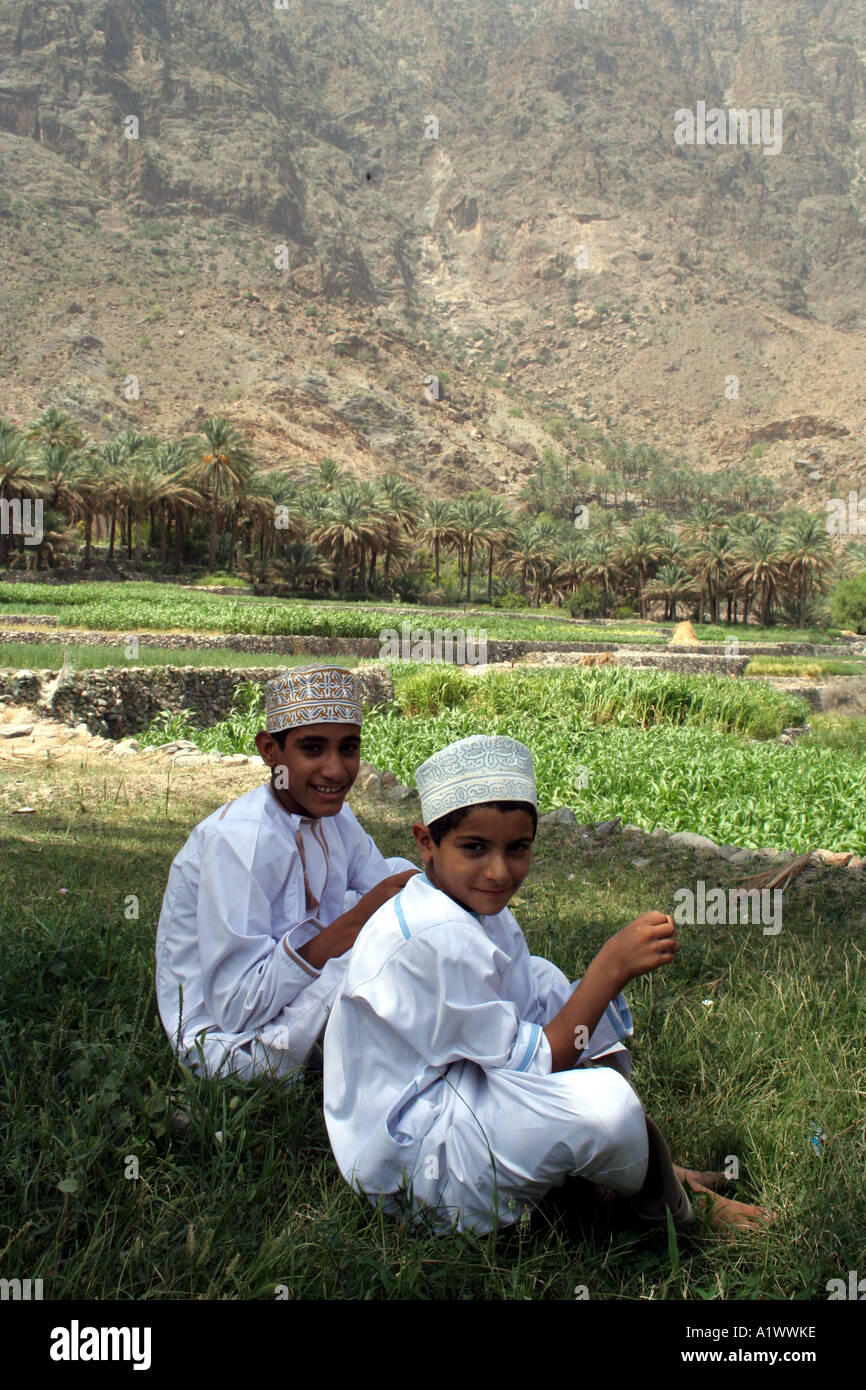 Boys resting in the shade, Bilad Sayt village Wadi Bani Hajar Mountains Oman Stock Photo