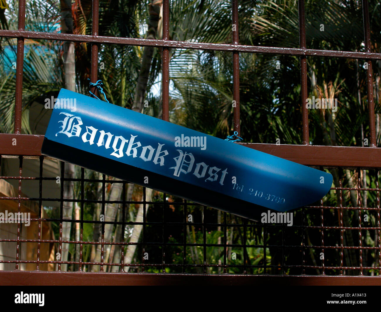 Newspaper rack with Bangkok Post logo mounted on domestic household entry gate in Bangkok Thailand Stock Photo