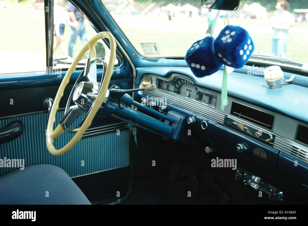 Fuzzy dice hanging from the rear view mirror of an old antique car Americana Stock Photo