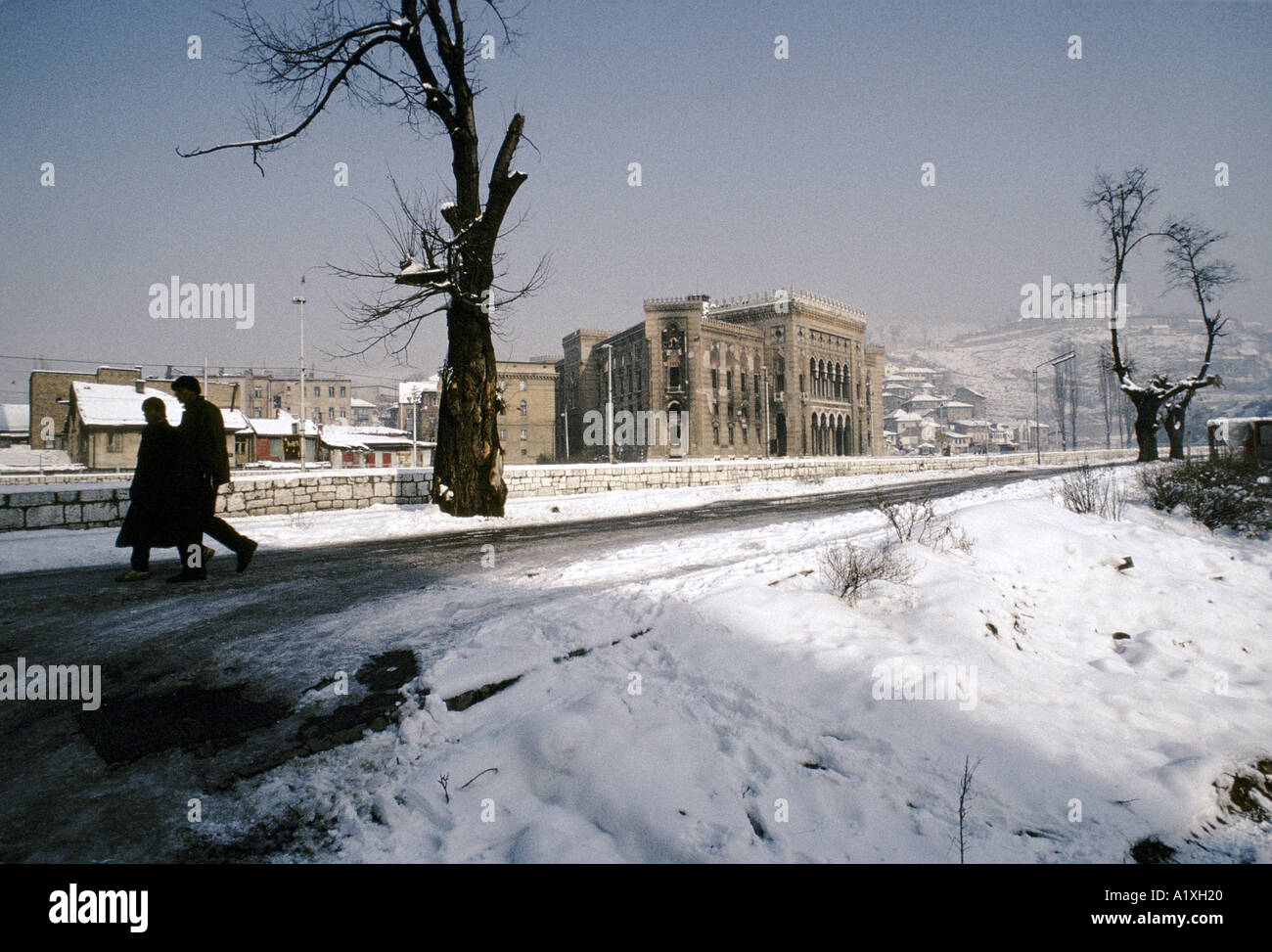 two men walking past the war damaged main city  library, Sarajevo, Bosnia 1994 Stock Photo