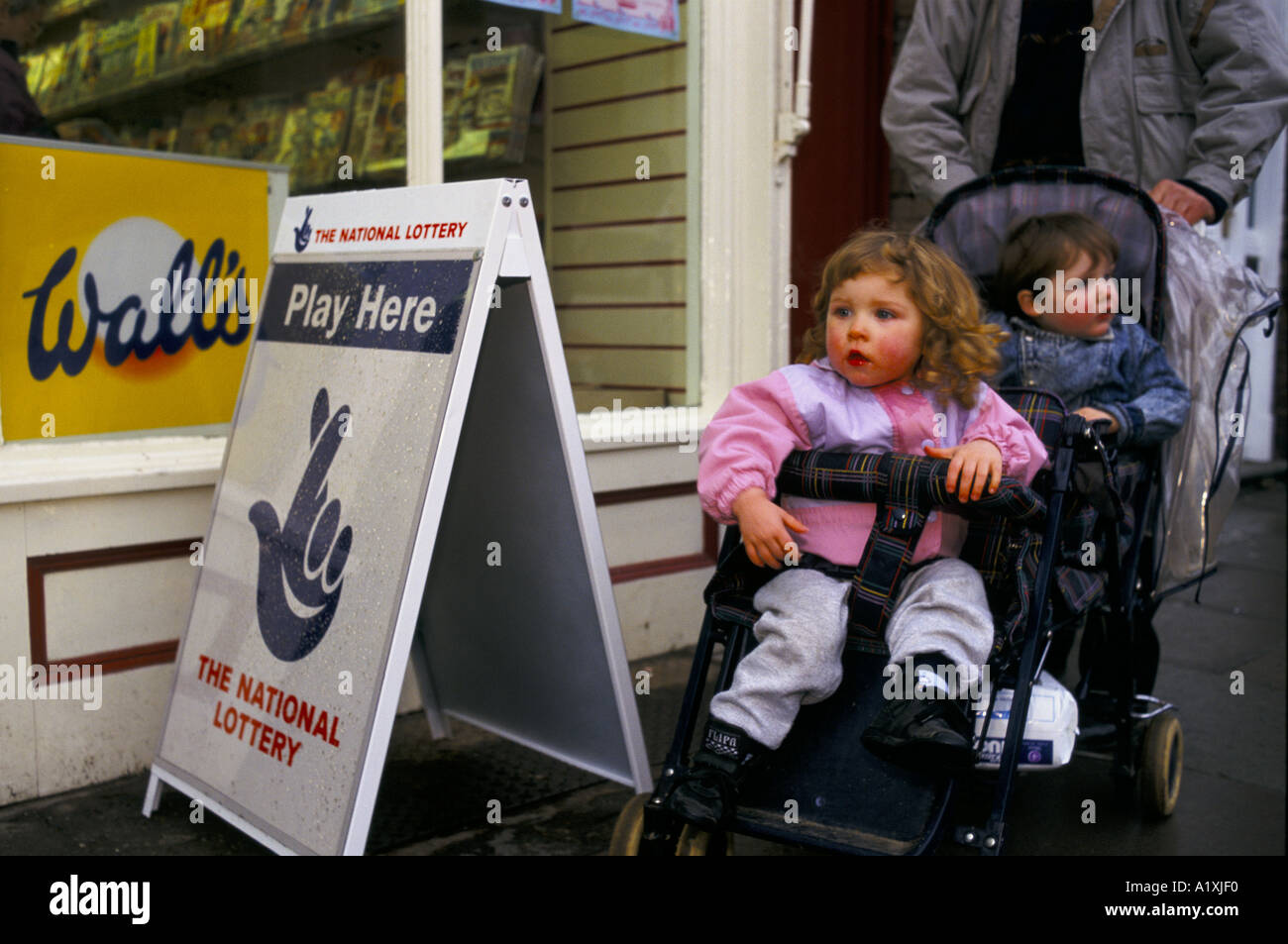 CHILDREN IN PUSHCHAIRS OUTSIDE NEWSAGENT NEWTOWN WALES NATIONAL LOTTERY MOST WINS Stock Photo