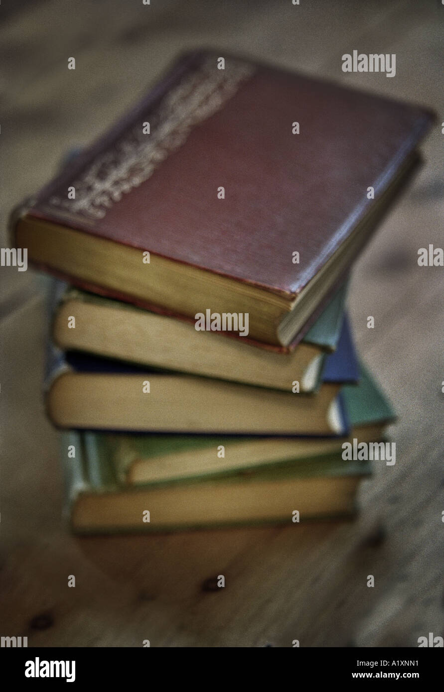 a stack of antique books on a wooden floor Stock Photo