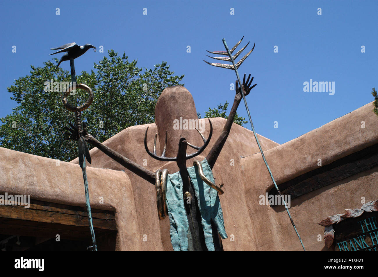 A spindly human figure like sculpture with a hart head its arms raised in front of a house in the Historic Old Town Stock Photo