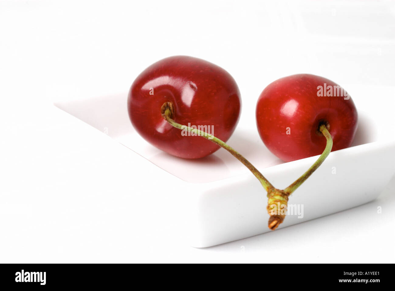 Pair of cherries in a white porcellain bowl Stock Photo