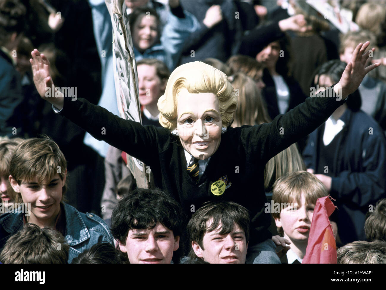CROWD OF YOUTHS ONE WEARING THATCHER MASK Stock Photo