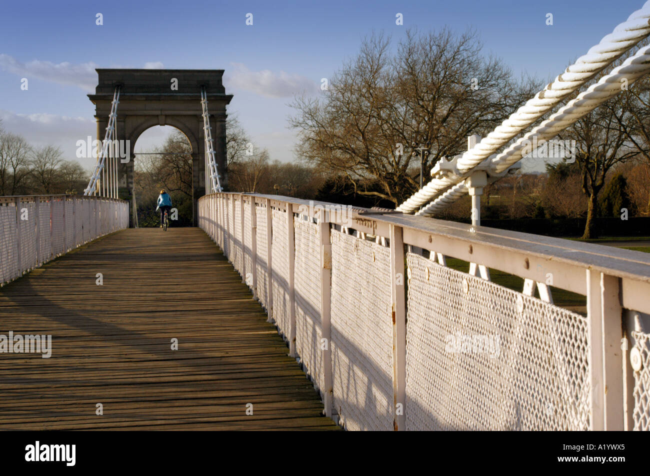 Cyclist on Wilford suspension bridge over river Trent, Nottingham Stock Photo