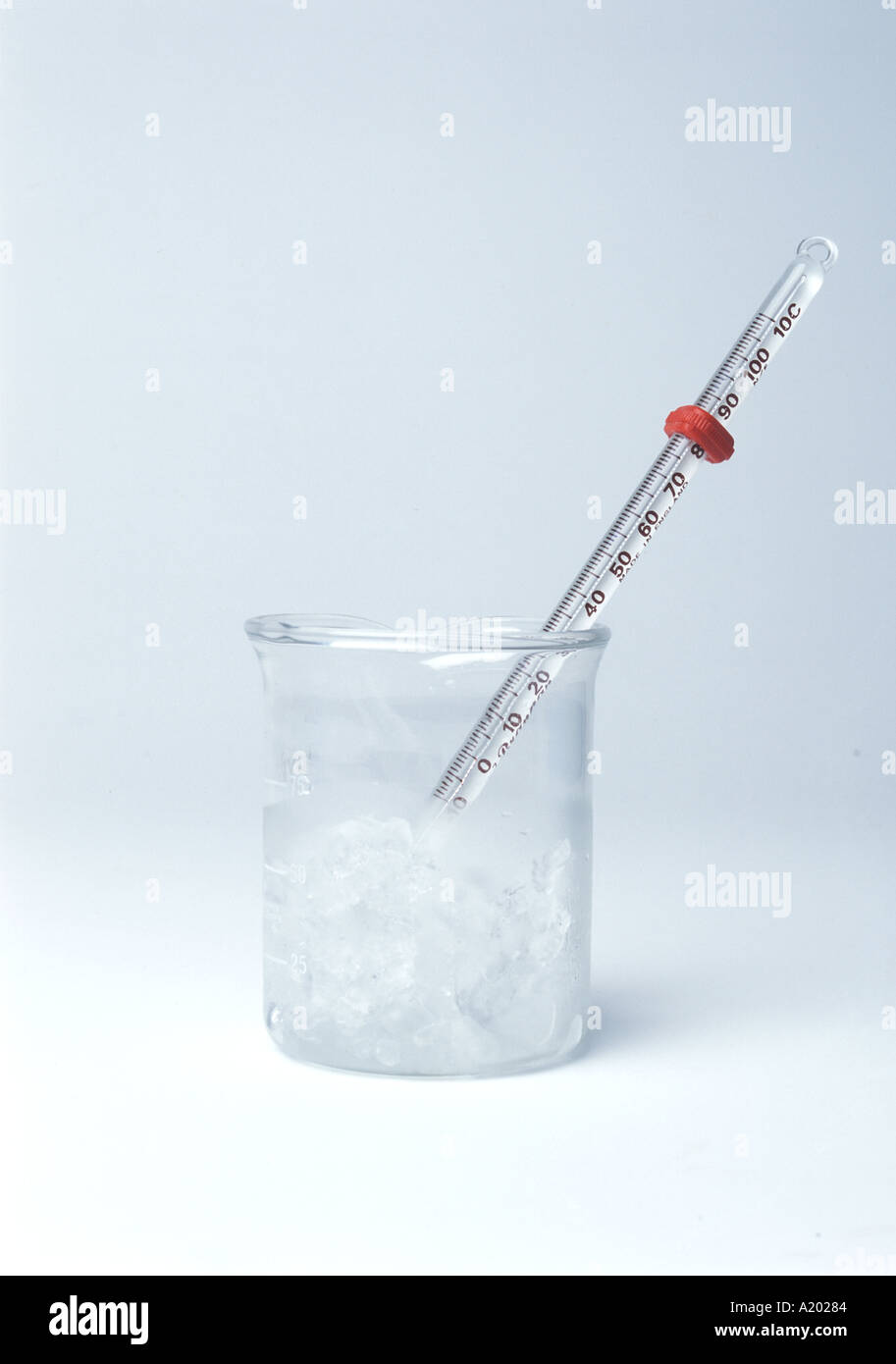 Thermometer in melting ice (0°C) shows temperature measurement and phase transitions in science experiments and thermodynamics. Isolated white. A20285 Stock Photo
