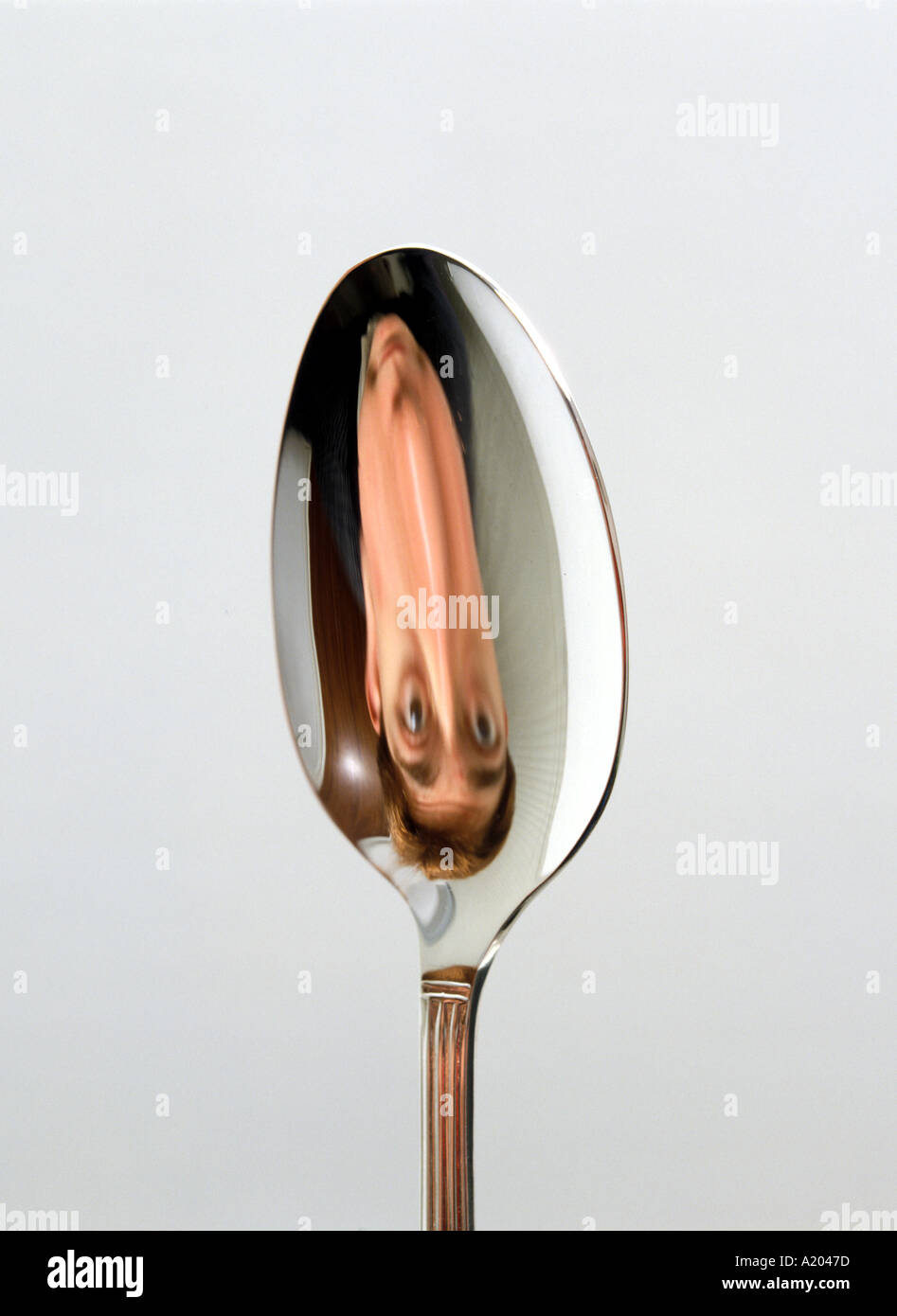 reflection in the concave side of a spoon image inverted upside down Stock Photo