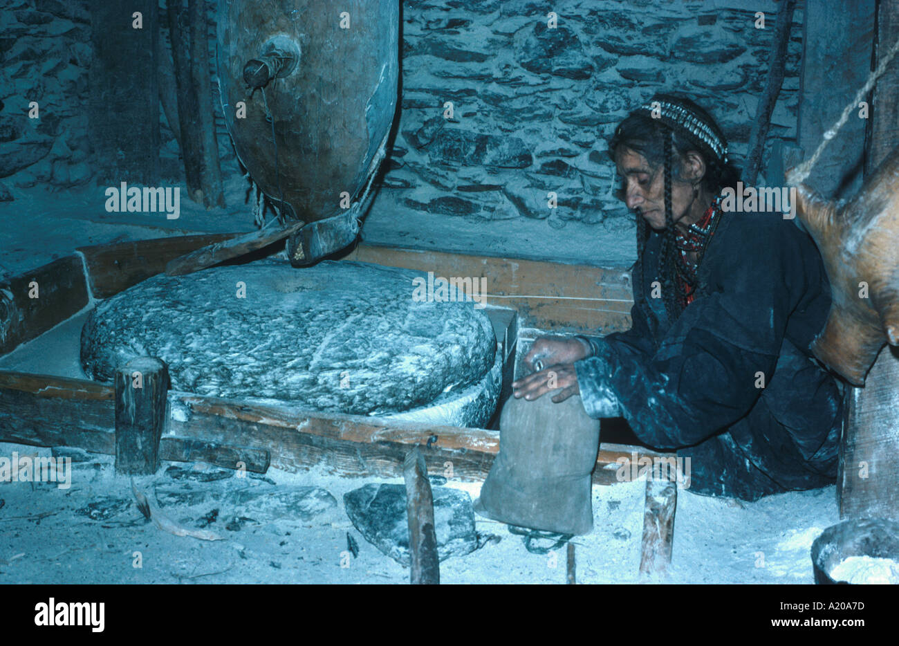 Kalash woman grinding maize at water mill Birrir Kafiristan NW Pakistan