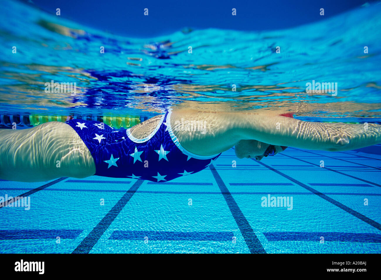 Young Woman Swimming Underwater In Pool Stock Photo
