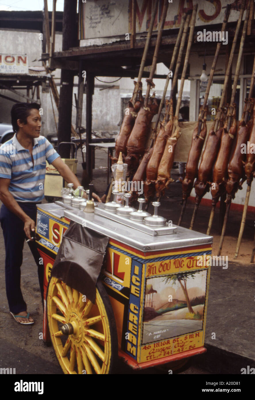 An ice cream vendor passing a take away lechon shop in Manila