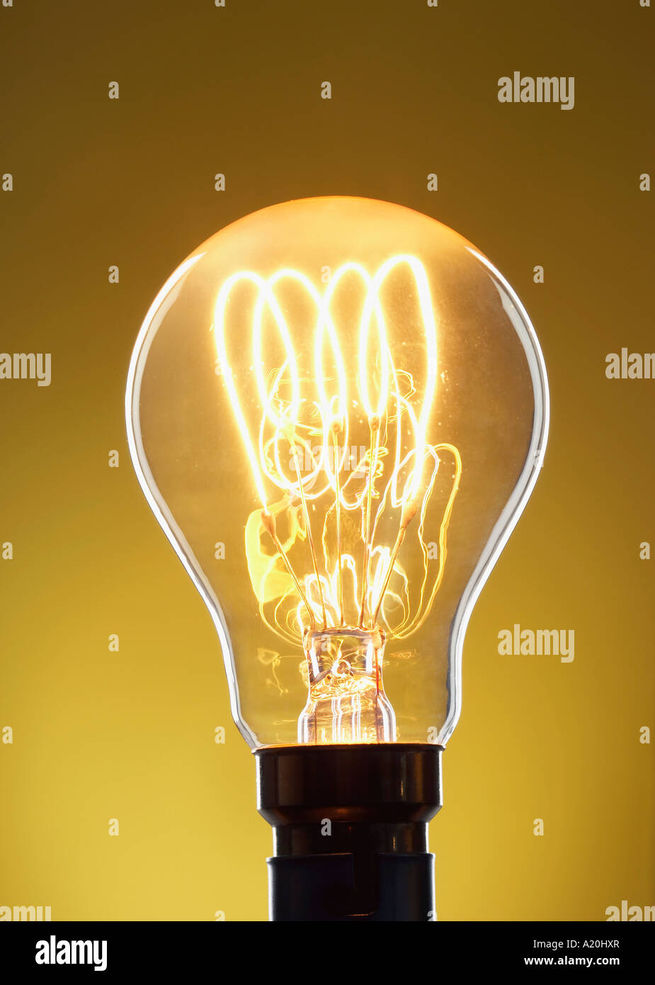Illuminated light bulb against yellow background in studio Stock Photo ...