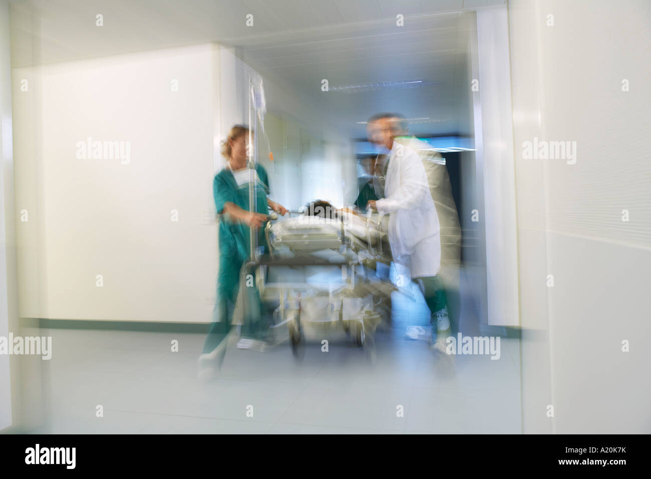 Doctors Moving Patient on gurney through hospital corridor, motion blur