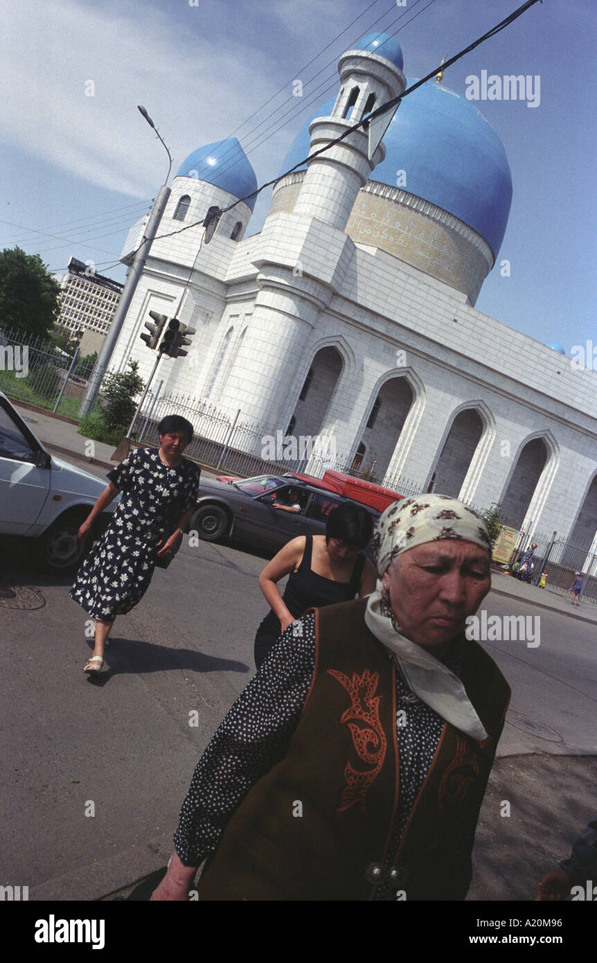 Women crossing a street in front of a newly built mosque in the center of Almaty, Kazakhstan Stock Photo