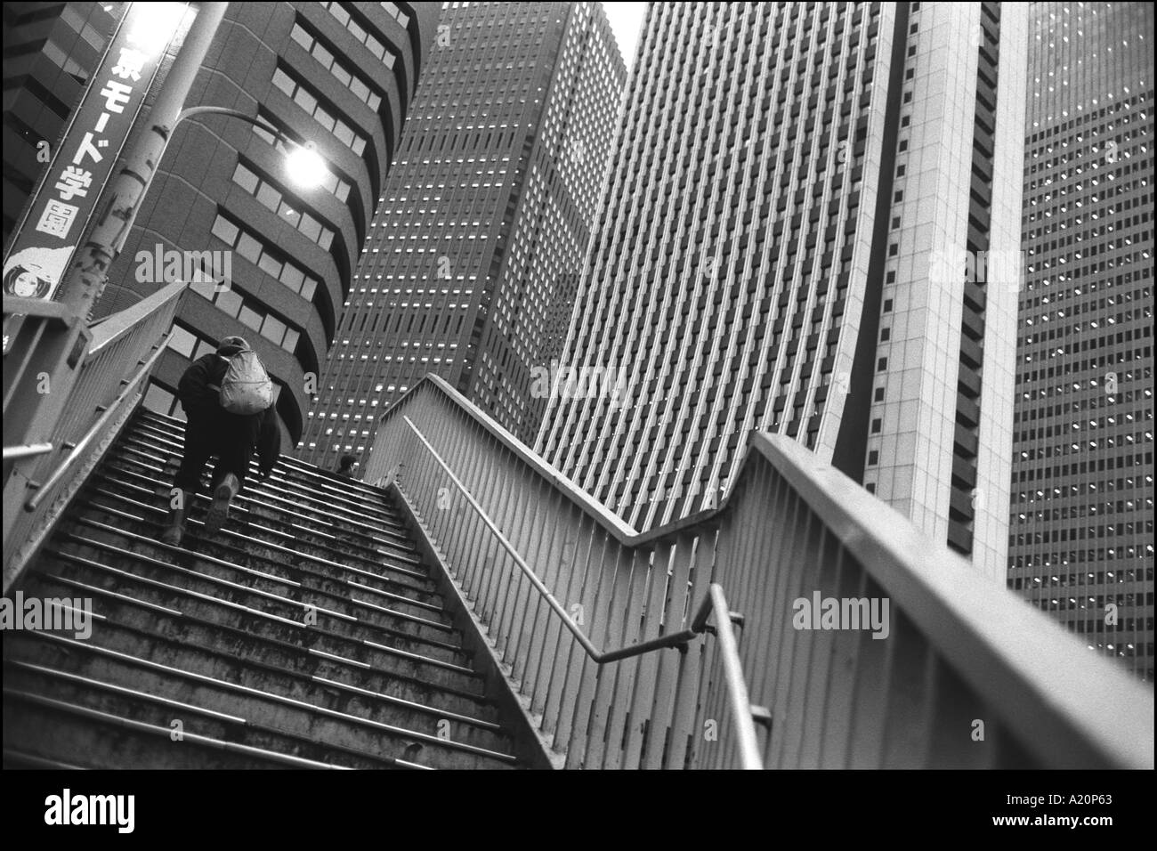 A man goes upstairs in the skyscraper business district of Nishi Shinjuku, Tokyo, Japan. Stock Photo