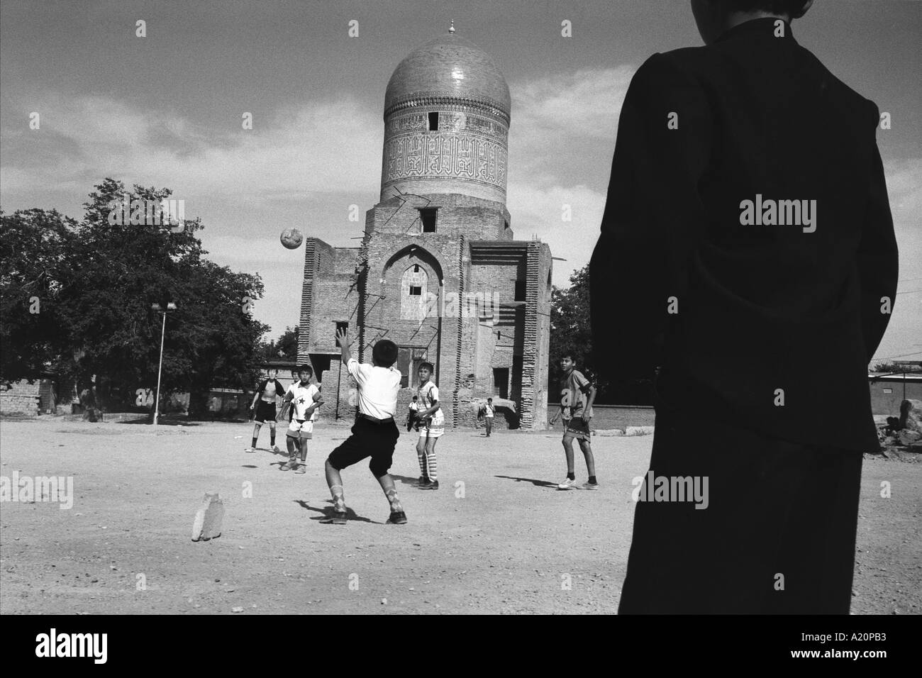 boys play football in front of the Bibi Khanym mausoleum in Samarkand the old Silk Road trading route city, Uzbekistan Stock Photo