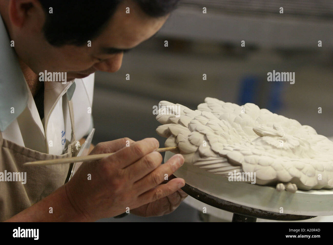 A craftsman at work sculpting a bird shaped piece of work within the Noritake China factory, Nagoya, Japan Stock Photo