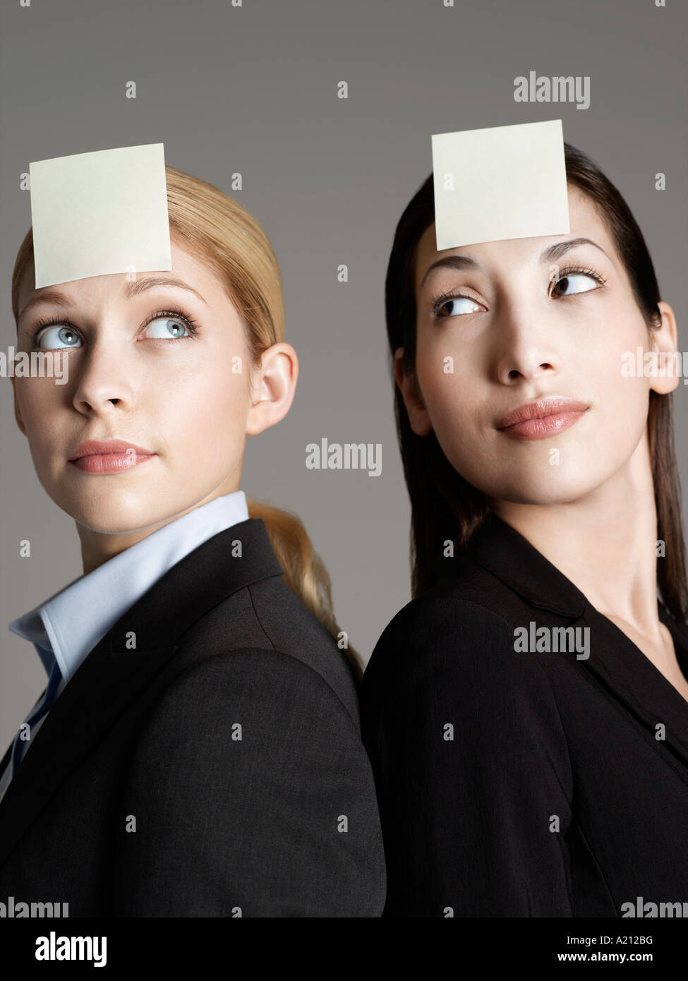 Portrait of two female office workers with sticky notes on forehead Stock Photo